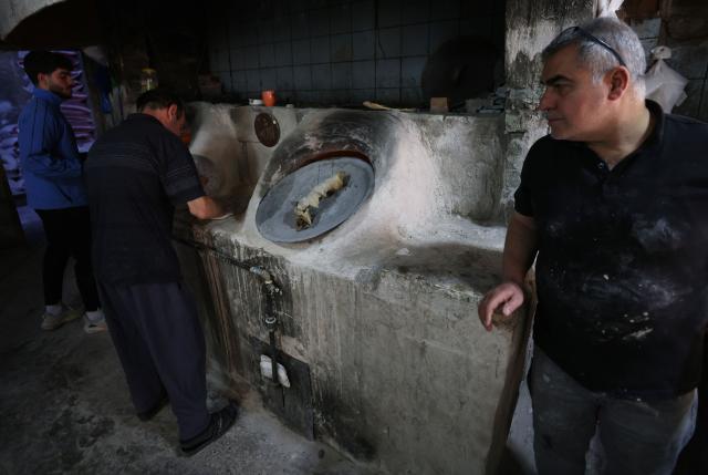 sIraqi baker prepare the bread in a bakery during the Muslim holy fasting month of Ramadan in Baghdad on February 19, 2026. Muslims throughout the world are marking the month of Ramadan, the holiest month in the Islamic calendar, during which devotees fast from dawn until dusk. (Photo by AHMAD AL-RUBAYE / AFP)