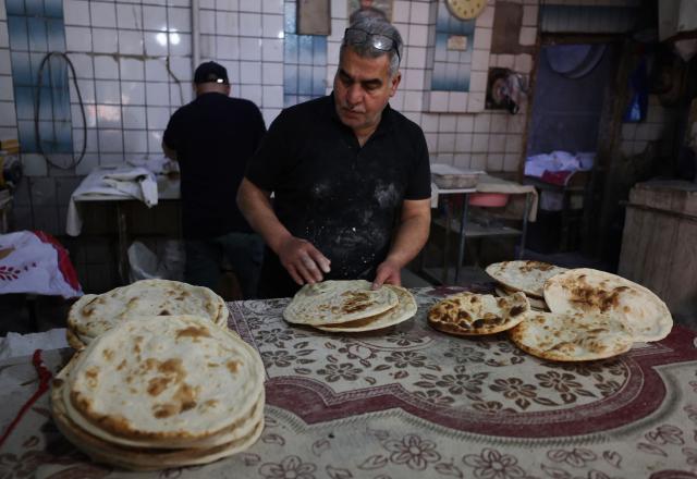 An Iraqi baker prepares bread in his bakery during the Muslim holy fasting month of Ramadan in Baghdad on February 19, 2026. Muslims throughout the world are marking the month of Ramadan, the holiest month in the Islamic calendar, during which devotees fast from dawn until dusk. (Photo by AHMAD AL-RUBAYE / AFP)