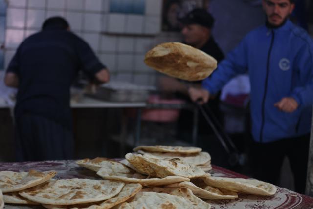 An Iraqi baker takes out the bread from a stone oven in his bakery during the Muslim holy fasting month of Ramadan in Baghdad on February 19, 2026. Muslims throughout the world are marking the month of Ramadan, the holiest month in the Islamic calendar, during which devotees fast from dawn until dusk. (Photo by AHMAD AL-RUBAYE / AFP)