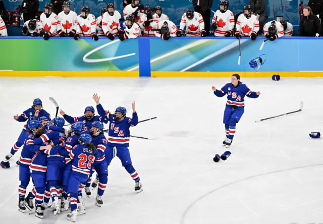 Canada's players (back) look on as USA's players celebrate winning the women's ice hockey at the Milano Santagiulia Ice Hockey Arena during the Milano Cortina 2026 Winter Olympic Games in Milan, on February 19, 2026. (Photo by Alexander NEMENOV / AFP)