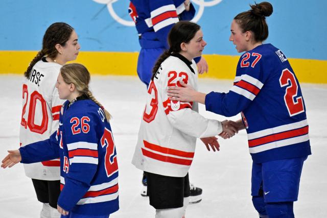 Players of Team USA and Team Canada shake hands prior to the medal ceremony for the women's ice hockey at the Milano Santagiulia Ice Hockey Arena during the Milano Cortina 2026 Winter Olympic Games in Milan, on February 19, 2026. (Photo by Alexander NEMENOV / AFP)