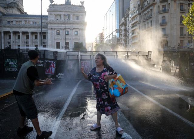 A demonstrator shouts slogans in front of a police barricade during a protest outside the Congress building, where Argentina's President Javier Milei's labour reform is being treated, in Buenos Aires on February 19, 2026. The contested reforms pushed by Argentina's President Javier Milei would make it easier to hire and fire workers in a country where job security is already hard to come by. It would also reduce severance pay, limit the right to strike, increase work hours and restrict holiday provisions. (Photo by TOMAS CUESTA / AFP)