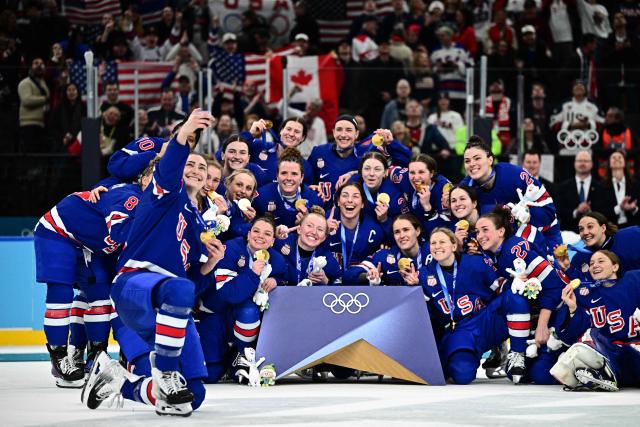Gold medallists USA pose for  a selfie during the medals ceremony for the women's ice hockey event at the Milano Santagiulia Ice Hockey Arena during the Milano Cortina 2026 Winter Olympic Games in Milan, on February 19, 2026. (Photo by JULIEN DE ROSA / AFP)