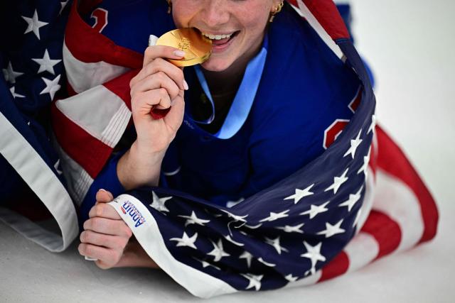 A USA player player poses  with the gold medal after the   women's ice hockey event at the Milano Santagiulia Ice Hockey Arena during the Milano Cortina 2026 Winter Olympic Games in Milan, on February 19, 2026. (Photo by JULIEN DE ROSA / AFP)