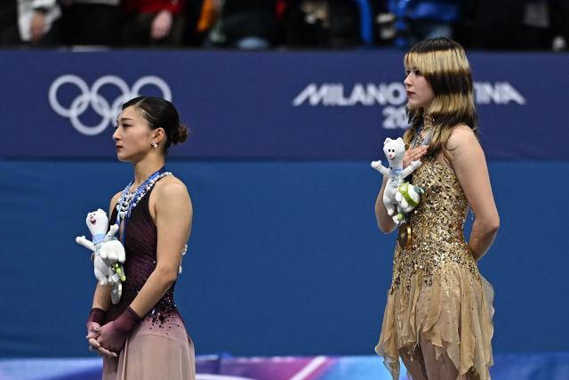 Silver medallist Japan's Kaori Sakamoto (L) and gold medallist USA's Alysa Liu (R) stand on the podium of the figure skating women's single free skating final during the Milano Cortina 2026 Winter Olympic Games at Milano Ice Skating Arena in Milan on February 19, 2026. (Photo by Gabriel BOUYS / AFP)