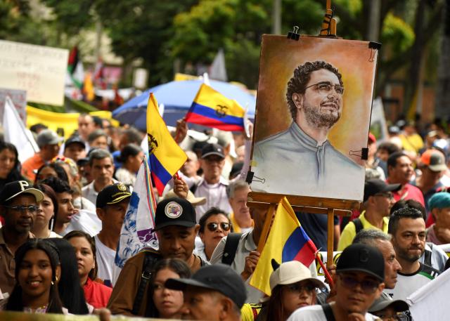 Supporters of Colombian presidential candidate for the Pacto Historico, Ivan Cepeda, show a portrait of him during a demonstration in Medellin, Colombia on February 19, 2026, to back the vital minimum wage decree, which was provisionally suspended by the Council of State. (Photo by Jaime SALDARRIAGA / AFP)