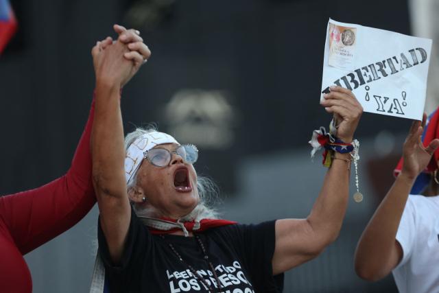 A relative shut slogas before the Venezuela’s National Assembly President Jorge Rodriguez speaking during a debate on an amnesty bill proposed by Venezuela’s interim president Delcy Rodriguez, outside the El Helicoide building, headquarters of the Bolivarian National Intelligence Service (SEBIN), in Caracas on February 19, 2026. Venezuela's Parliament resumed on February 19 the debate on an amnesty bill that could free hundreds of political prisoners. (Photo by Pedro MATTEY / AFP)