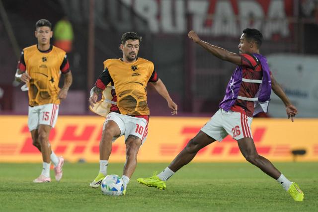 Flamengo's Uruguayan midfielder #10 Giorgian de Arrascaeta and Flamengo's defender #26 Alex Sandro vie for the ball during the warm-up before the start of the Recopa Sudamericana first leg final football match between Argentina's Lanus and Brazil's Flamengo at the Ciudad de Lanus Stadium in Lanus, Buenos Aires province, on February 19, 2026. (Photo by JUAN MABROMATA / AFP)