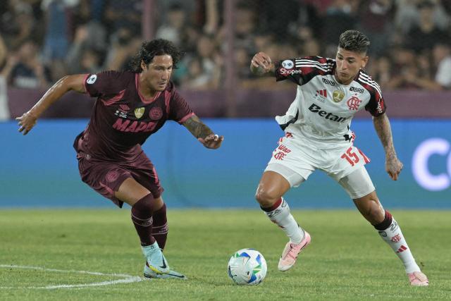 Lanus' defender #13 Jose Maria Canale and Flamengo's Colombian midfielder #15 Jorge Carrascal fight for the ball during the Recopa Sudamericana first leg final football match between Argentina's Lanus and Brazil's Flamengo at the Ciudad de Lanus Stadium in Lanus, Buenos Aires province, on February 19, 2026. (Photo by JUAN MABROMATA / AFP)