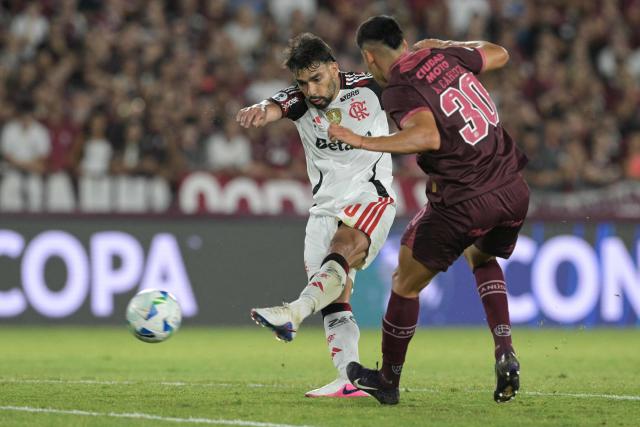 Flamengo's midfielder #20 Lucas Paqueta and Lanus' midfielder #30 Agustin Cardozo fight for the ball during the Recopa Sudamericana first leg final football match between Argentina's Lanus and Brazil's Flamengo at the Ciudad de Lanus Stadium in Lanus, Buenos Aires province, on February 19, 2026. (Photo by JUAN MABROMATA / AFP)