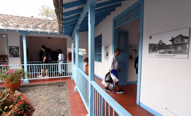 Tourists visit a house in El Pueblito Paisa, a scale replica of a traditional 20th-century Antioquian village, located atop Nutibara Hill in Medellin, Colombia on February 18, 2026. (Photo by JAIME SALDARRIAGA / AFP)