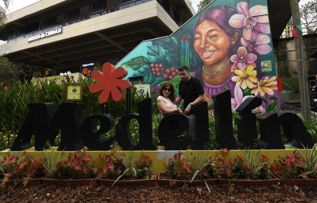 A couple poses for a photo at El Pueblito Paisa, a scale replica of a traditional 20th-century Antioquian village, located atop Nutibara Hill in Medellin, Colombia on February 18, 2026. (Photo by JAIME SALDARRIAGA / AFP)