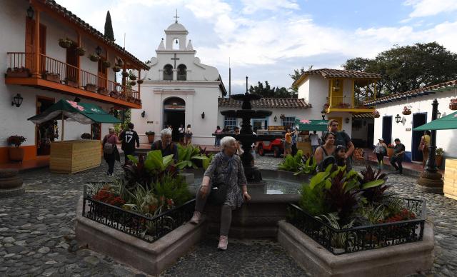 Tourists visit El Pueblito Paisa, known for being a scale replica of a traditional 20th-century Antioquian village, located atop Cerro Nutibara in Medellin, Colombia on February 18, 2026. (Photo by JAIME SALDARRIAGA / AFP)