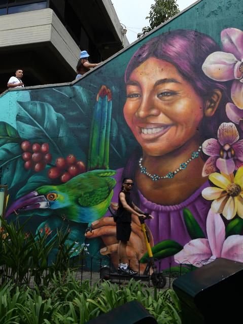 Tourists walk past a mural at El Pueblito Paisa, a scale replica of a traditional 20th-century Antioquian village, located atop Nutibara Hill in Medellin, Colombia on February 18, 2026. (Photo by JAIME SALDARRIAGA / AFP)