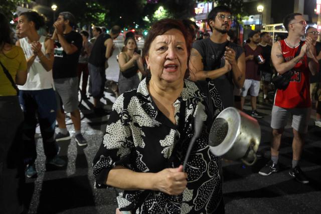 People take part in a pot-banging protest against Argentina's President Javier Milei's labour reform in Buenos Aires on February 19, 2026. The contested reforms would make it easier to hire and fire workers in a country where job security is already hard to come by, and would also reduce severance pay, limit the right to strike, increase work hours and restrict holiday provisions. (Photo by Tomas CUESTA / AFP)