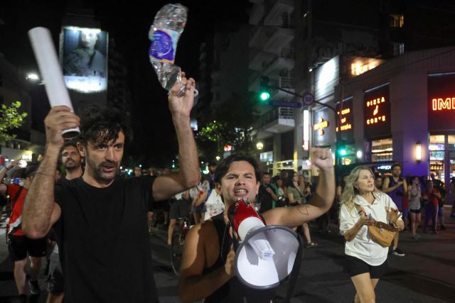 People take part in a pot-banging protest against Argentina's President Javier Milei's labour reform in Buenos Aires on February 19, 2026. The contested reforms would make it easier to hire and fire workers in a country where job security is already hard to come by, and would also reduce severance pay, limit the right to strike, increase work hours and restrict holiday provisions. (Photo by Tomas CUESTA / AFP)