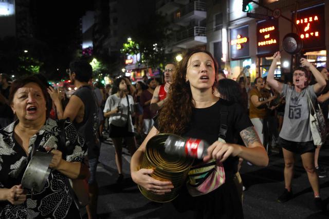 People take part in a pot-banging protest against Argentina's President Javier Milei's labour reform in Buenos Aires on February 19, 2026. The contested reforms would make it easier to hire and fire workers in a country where job security is already hard to come by, and would also reduce severance pay, limit the right to strike, increase work hours and restrict holiday provisions. (Photo by Tomas CUESTA / AFP)