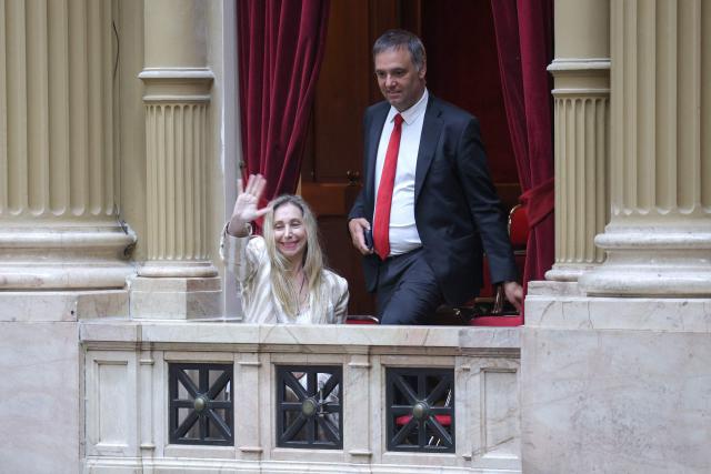 Argentina's Secretary General of the Presidency Karina Milei (L) and Chief of Cabinet and government spokesman Manuel Adorni (C) arrive at the chamber of deputies during a session to debate labor law reforms at the National Congress in Buenos Aires, early on February 20, 2026. The contested reforms pushed by Argentina's President Javier Milei would make it easier to hire and fire workers in a country where job security is already hard to come by. It would also reduce severance pay, limit the right to strike, increase work hours and restrict holiday provisions. (Photo by Tomas CUESTA / AFP)