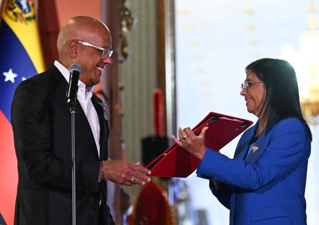 Venezuela's interim president Delcy Rodriguez receives the amnesty law from the president of the National Assembly Jorge Rodriguez at the Miraflores Palace in Caracas on February 19, 2026. Venezuela's Parliament unanimously approved on February 19 a historic amnesty law that is expected to lead to the release of hundreds of political prisoners after 27 years of Chavismo. (Photo by Juan BARRETO / AFP)