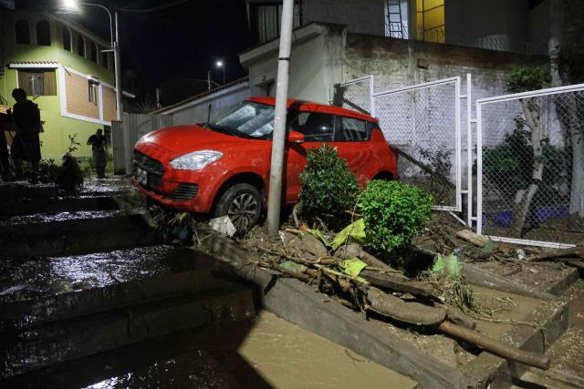 This view shows a car affected by flooding caused by heavy rains in the Yanahuara district of Arequipa, southern Peru, on February 19, 2026 (Photo by Juan Santy / AFP)