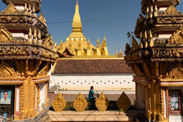 A man rides past the Thatluang Stupa in Vientiane on February 19, 2026. (Photo by AFP)