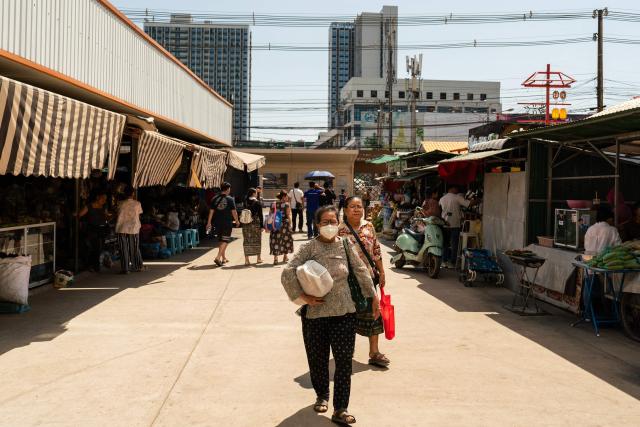 People walk past stalls at a market in downtown Vientiane on February 19, 2026. (Photo by AFP)