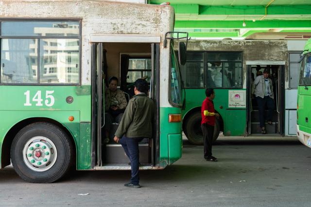 Passengers are seen next to commuter buses in downtown Vientiane on February 19, 2026. (Photo by AFP)