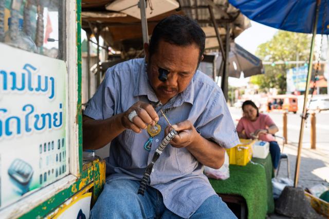 A watch repairer works at his stall in downtown Vientiane on February 19, 2026. (Photo by AFP)