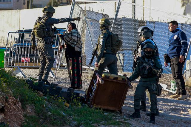 Israeli soldiers speaks with a Palestinian woman at the Qalandia checkpoint in the occupied West Bank city of Ramallah on February 20, 2026, as she tries to enter Jerusalem on her way to Al-Aqsa Mosque for the first Friday noon prayers of the Islamic holy month of Ramadan. (Photo by Jaafar ASHTIYEH / AFP)