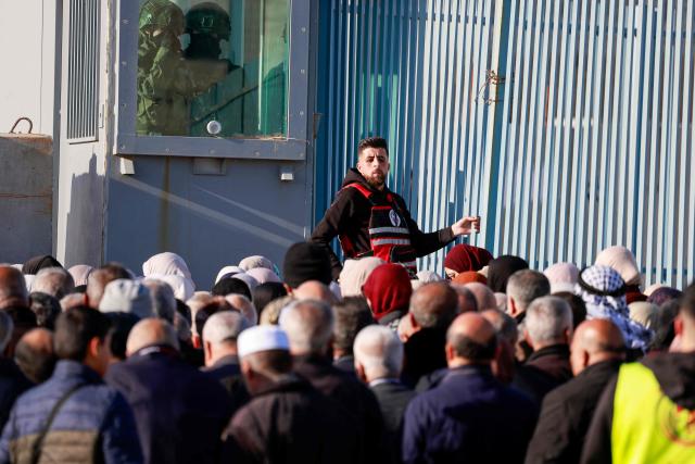 Israeli soldiers keep watch as Palestinian Muslims gather at the Qalandia checkpoint in the occupied West Bank city of Ramallah on February 20, 2026, to enter Jerusalem on their way to Al-Aqsa Mosque for the first Friday noon prayers of the Islamic holy month of Ramadan. (Photo by Jaafar ASHTIYEH / AFP)