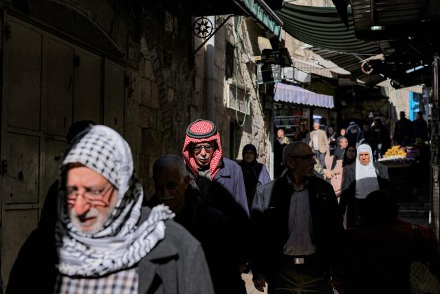 People walk along an alley in the old city of Jerusalem on the first Friday of the Muslim holy month of Ramadan on February 20, 2026. (Photo by Ilia YEFIMOVICH / AFP)