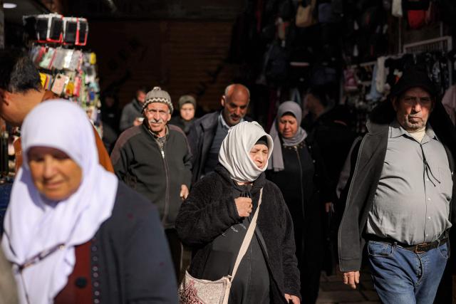 People walk along an alley in the old city of Jerusalem on the first Friday of the Muslim holy month of Ramadan on February 20, 2026. (Photo by Ilia YEFIMOVICH / AFP)
