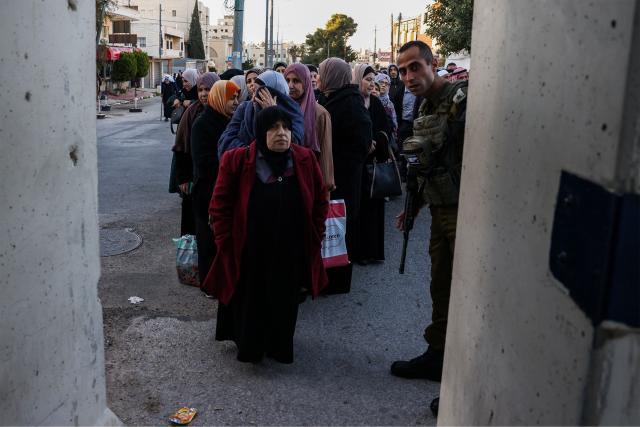 Palestinian Muslims gather at a checkpoint in the occupied West Bank city of Ramallah on February 20, 2026, to enter Jerusalem on their way to Al-Aqsa Mosque for the first Friday noon prayers of the Islamic holy month of Ramadan. (Photo by HAZEM BADER / AFP)