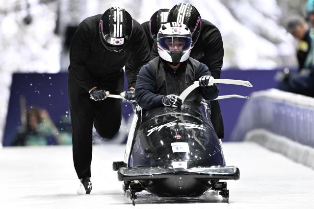 Team South-Korea including pilot South Korea's Suk Youngjin (Bottom C) take part in the bobsleigh men's 4-man training session at Cortina Sliding Centre during the Milano Cortina 2026 Winter Olympic Games in Cortina d'Ampezzo on February 20, 2026. (Photo by Tiziana FABI / AFP)