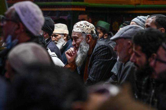 A Muslim devotee reacts as people pray on the first Friday of the Islamic holy month of Ramadan at the Sheikh Syed Abdul Qadir Jeelani shrine in Srinagar on February 20, 2026. (Photo by Tauseef MUSTAFA / AFP)
