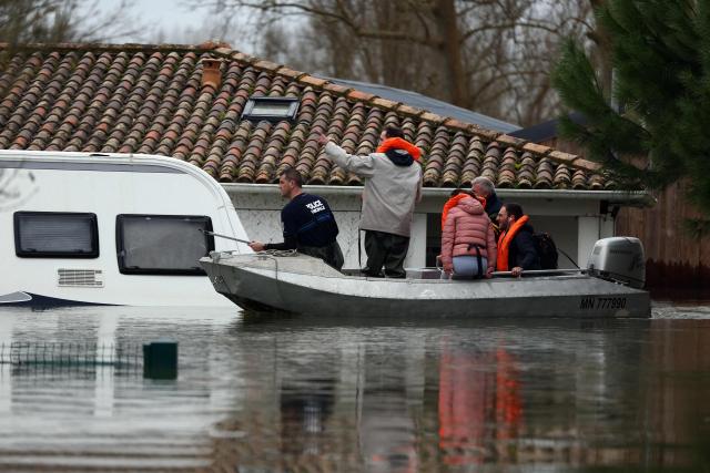 TOPSHOT - Rescuers carry inhabitants by boat in a flooded street following heavy rain causing the flooding of the Charente river in Saintes, southwestern France on February 20, 2026. (Photo by ROMAIN PERROCHEAU / AFP)