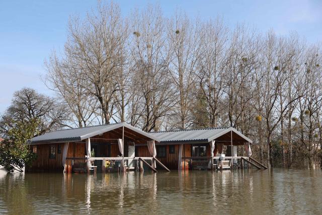 Flooded houses are pictured following heavy rain causing the flooding of the Charente river in Chaniers, southwestern France on February 20, 2026. (Photo by ROMAIN PERROCHEAU / AFP)