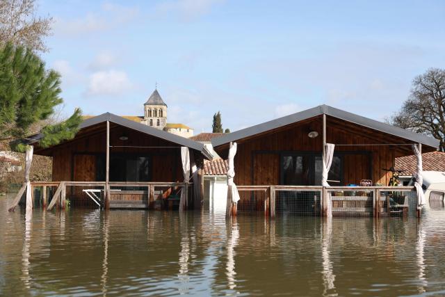 Flooded houses are pictured following heavy rain causing the flooding of the Charente river in Chaniers, southwestern France on February 20, 2026. (Photo by ROMAIN PERROCHEAU / AFP)