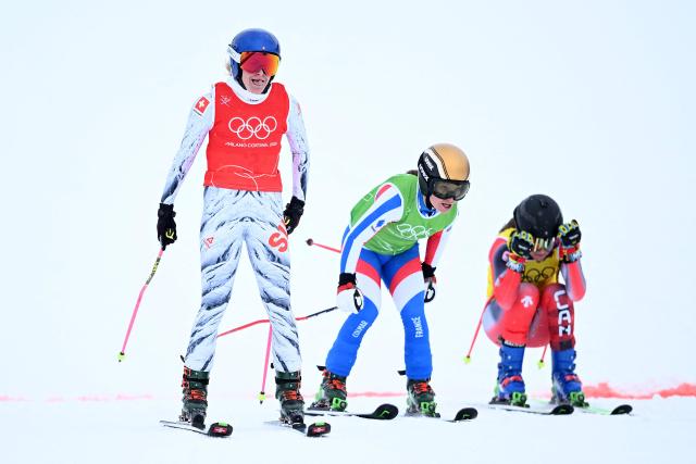 (L-R) Switzerland's Fanny Smith, France's Jade Grillet Aubert and Canada's Brittany Phelan cross the finish-line in the freestyle skiing women's ski cross quarter final 3 during the Milano Cortina 2026 Winter Olympic Games at Livigno Snow Park, in Livigno (Valtellina), on February 20, 2026. (Photo by Kirill KUDRYAVTSEV / AFP)