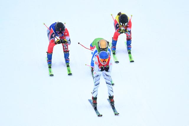 (L-R) Canada's Hannah Schmidt, Switzerland's Fanny Smith, France's Jade Grillet Aubert and Canada's Brittany Phelan compete in the freestyle skiing women's ski cross quarter final 3 during the Milano Cortina 2026 Winter Olympic Games at Livigno Snow Park, in Livigno (Valtellina), on February 20, 2026. (Photo by Kirill KUDRYAVTSEV / AFP)