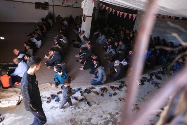Displaced Palestinians gather to pray on the first Friday noon prayers of the holy month of Ramadan, next to the destroyed Al-Huda Mosque, in Khan Yunis in the southern Gaza Strip on February 20, 2026. Nearly all of Gaza's 2.2 million residents were displaced at least once during the more than two years of war between Israel and Hamas, sparked by the latter's unprecedented October 7 attack on Israel. (Photo by Bashar Taleb / AFP)