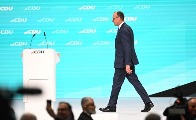 German Chancellor and leader of Germany's Christian Democratic Union (CDU) Friedrich Merz leaves the stage after giving a speech during their CDU party's congress in Stuttgart, southern Germany, on February 20, 2026. (Photo by THOMAS KIENZLE / AFP)