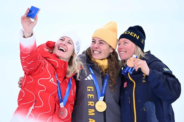 (From L) Silver medallist Switzerland's Fanny Smith, gold medallist Germany's Daniela Maier and bronze medallist Sweden's Sandra Naeslund pose on the podium after the freestyle skiing women's ski cross final during the Milano Cortina 2026 Winter Olympic Games at Livigno Snow Park, in Livigno (Valtellina), on February 20, 2026. (Photo by Kirill KUDRYAVTSEV / AFP)