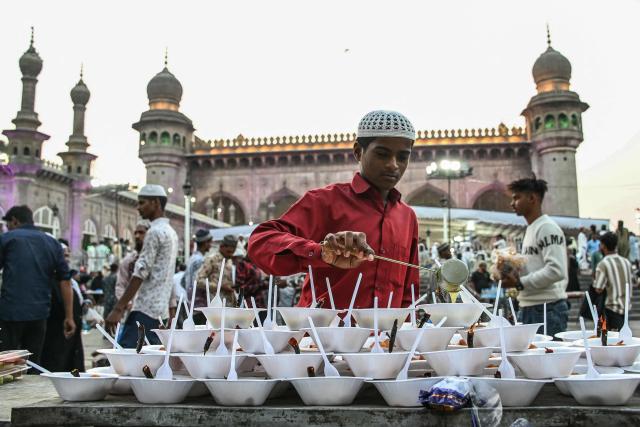 A Muslim boy prepares iftar meals on the first Friday of the Islamic holy month of Ramadan at the Mecca Masjid in Hyderabad on February 20, 2026. (Photo by Noah SEELAM / AFP)