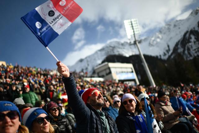 A fan of France cheers during the men's biathlon 15km mass start event during the Milano Cortina 2026 Winter Olympic Games at the Anterselva Biathlon Arena (Sudtirol Arena) in Anterselva (Val Pusteria) on February 20, 2026. (Photo by Marco BERTORELLO / AFP)