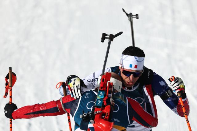 Gold medallist Norway's Johannes Dale-Skjevdal (L) celebrates with silver medallist France's Quentin Fillon Maillet after the men's biathlon 15km mass start event during the Milano Cortina 2026 Winter Olympic Games at the Anterselva Biathlon Arena (Sudtirol Arena) in Anterselva (Val Pusteria) on February 20, 2026. (Photo by FRANCK FIFE / AFP)