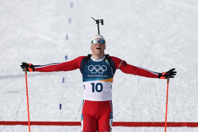 Norway's Johannes Dale-Skjevdal celebrates as he crosses the finish line to win gold during the men's biathlon 15km mass start event during the Milano Cortina 2026 Winter Olympic Games at the Anterselva Biathlon Arena (Sudtirol Arena) in Anterselva (Val Pusteria) on February 20, 2026. (Photo by FRANCK FIFE / AFP)