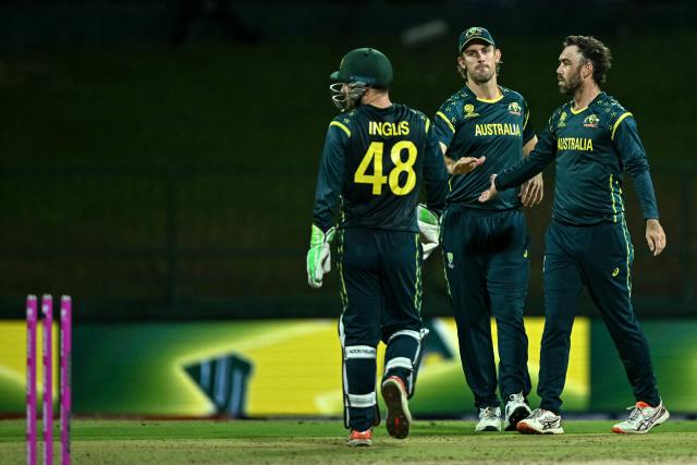 Australia's Glenn Maxwell (R) celebrates with teammates after taking the wicket of Oman's Wasim Ali during the 2026 ICC Men's T20 Cricket World Cup group stage match between Oman and Australia at Pallekele International Cricket Stadium in Kandy on February 20, 2026. (Photo by Ishara S. KODIKARA / AFP)