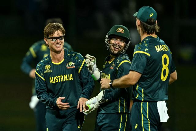 Australia's Adam Zampa (L) celebrates with teammates after taking the wicket of Oman's Shakeel Ahmed during the 2026 ICC Men's T20 Cricket World Cup group stage match between Oman and Australia at Pallekele International Cricket Stadium in Kandy on February 20, 2026. (Photo by Ishara S. KODIKARA / AFP)