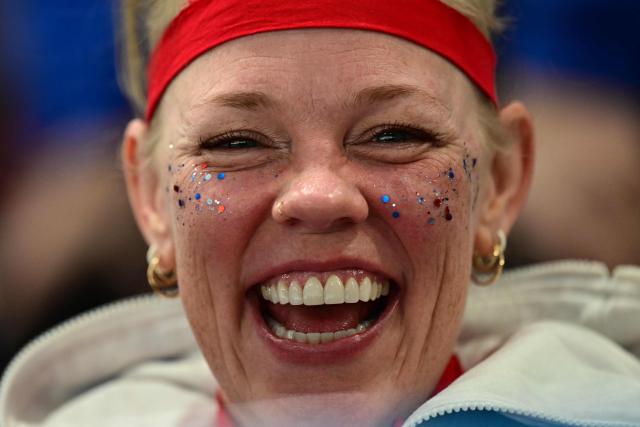 A USA fan smiles while watching the curling women's round robin semi-final between USA and Switzerland during the Milano Cortina 2026 Winter Olympic Games at the Cortina Curling Olympic Stadium in Cortina d’Ampezzo on February 20, 2026. (Photo by Stefano RELLANDINI / AFP)